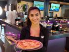 Friendly server with pizza at Chaser's Sports Bar in Schiller Park