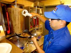 Grill man slicing the famous Gyros at Charcoal Delights Restaurant in Chicago