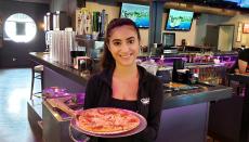 Friendly server with pizza at Chaser's Sports Bar & Grill in Schiller Park