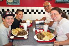 Family feasting on hearty gyros plates at Plush Pup Gyros Restaurant in Norwood Park