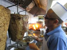 Grill man slicing homemade gyros at Nick's Drive In Restaurant in Chicago