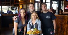 Friendly staff with nachos at Niko's Tavern in Elgin