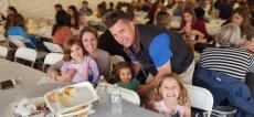 Family enjoying dinner at St. Demetrios Greek Fest in Elmhurst